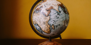 Globus Globus vor gelber Wand